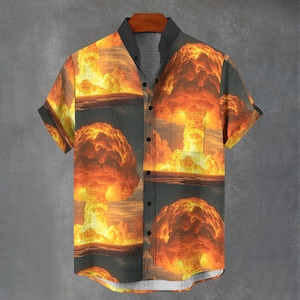 May include: A short-sleeved button-down shirt with a repeating pattern of orange and yellow mushroom clouds.