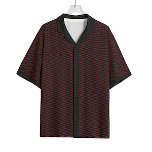 May include: Short-sleeved button-down shirt with a black collar and trim. The shirt features a repeating red zigzag pattern on a black background. The shirt is hanging on a white hanger.