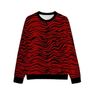 May include: A red and black patterned sweatshirt. The long-sleeved top features a bold design of black stripes against a red background. The collar and cuffs are black. The shirt is a crew neck style.