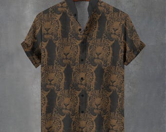 May include: Short-sleeved button-down shirt with a repeating pattern of jaguar faces in shades of brown and black. The shirt has a classic collar and is displayed on a wooden hanger against a gray background. The shirt's design is a bold statement.