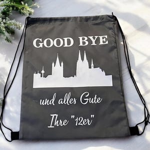 Może przedstawiać: Szary worek ze sznurkiem z białym napisem "GOOD BYE". Poniżej biała sylwetka panoramy miasta. Dodatkowy biały tekst znajduje się pod panoramą.