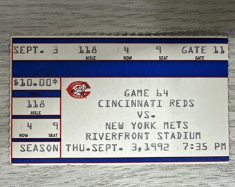 May include: A vintage Cincinnati Reds vs. New York Mets baseball game ticket from Riverfront Stadium, dated September 3, 1992. The ticket features the Reds logo and game details, including the gate, aisle, row, and seat information.