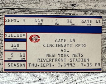 May include: A vintage Cincinnati Reds vs. New York Mets baseball game ticket from September 3, 1992. The ticket features the Reds logo, game details, and seat information. The ticket is rectangular with blue and red accents.