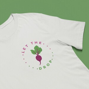 May include: White t-shirt with a green beet illustration and the text "Let the... Drop." in a circle.