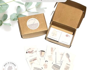 Könnte beinhalten: Ein Set mit 10 Magnetkarten mit Illustrationen und deutschem Text. Die Karten befinden sich in einer braunen Box mit einem Etikett, auf dem "Pic Your Day" steht. Die Box ist geöffnet und die Karten sind sichtbar. Die Karten sind 4x4 cm groß.