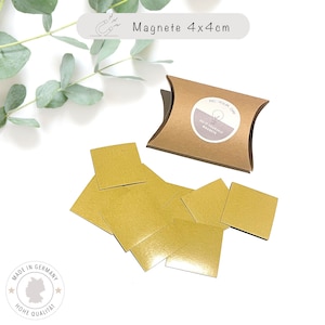 May include: A set of eight gold square magnets, each measuring 4x4 cm, packaged in a brown pillow box. The box has a label that reads "Do It Yourself Magnets".