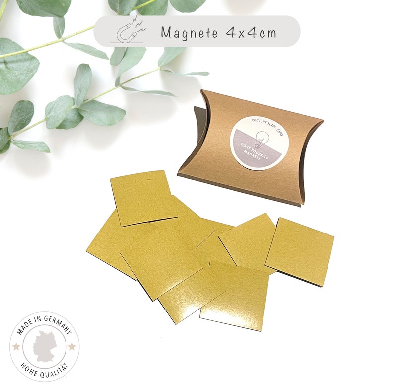 May include: A set of eight gold square magnets, each measuring 4x4 cm, packaged in a brown pillow box. The box has a label that reads "Do It Yourself Magnets".