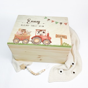 Könnte beinhalten: Eine Holz-Erinnerungskiste mit einem Bauernhof-Tier-Motiv. Der Deckel zeigt einen roten Traktor mit einer Kuh, einem Schwein und anderen Tieren. Die Kiste ist personalisiert mit dem Namen "Enny", dem Datum "05.11.2021", dem Gewicht "2505 g", der Länge "50 cm" und der Uhrzeit "10:43 Uhr".