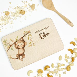 Könnte beinhalten: Ein Holzbrett mit einer Affenillustration und dem Text "HIER KRÜMELT Robin".