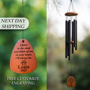 May include: A wooden wind chime with black tubes and a brown wooden top and bottom. The chime includes a wooden tag with the text "Listen to the wind and think of me. In your heart, I'll always be. Louie 2025."