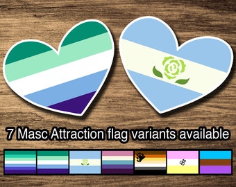 May include: Two heart-shaped stickers with different pride flags. The left sticker features a green, light green, white, light blue, and purple striped flag. The right sticker features a light blue flag with a white stripe and a green rose with leaves. The text "7 Masc Attraction flag variants available" is below the stickers. A row of seven smaller stickers with different pride flags is below the text.