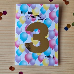 Age birthday greeting card with foil number and coloured balloons