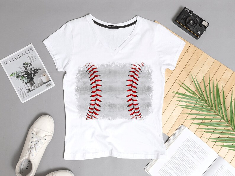 May include: White V-neck t-shirt with a distressed baseball graphic in red and gray.