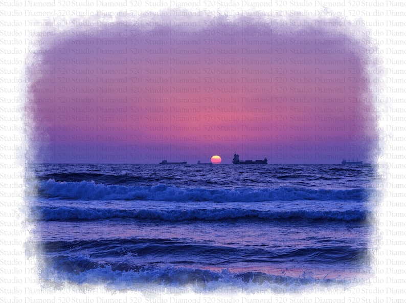 May include: A vibrant sunset over the ocean with a deep blue hue. The sun is setting in the distance, casting a warm glow on the water. The sky is a mix of pink, purple, and orange.
