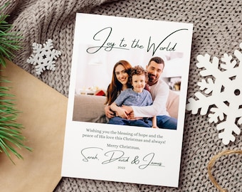May include: A Christmas card with a photo of a family of three, a woman, a man, and a young boy. The card has the text "Joy to the World" and "Wishing you the blessing of hope and the peace of His love this Christmas and always! Merry Christmas, Sarah, David & James 2022."