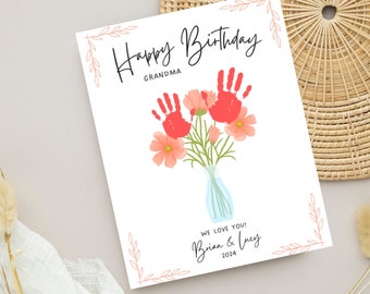May include: A white card with a handprint flower bouquet design. The card says "Happy Birthday Grandma" and "We love you! Brian & Lucy 2024".