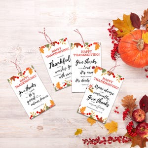 May include: Four printable Thanksgiving gift tags with autumn foliage and berry designs. Each tag features a different Bible verse about giving thanks. The text on the tags reads: "Happy Thanksgiving! Give thanks to the Lord, for He is good and His love endures forever." "Happy Thanksgiving! Let us be thankful and worship God with reverence and awe." "Happy Thanksgiving! Give thanks to the Lord, for His name is to be praised. Make known His deeds among the peoples." "Happy Thanksgiving! Rejoice always, continually give thanks in all circumstances."