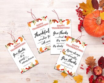 May include: Four printable Thanksgiving gift tags with fall foliage and berry designs. Each tag features a different Bible verse about giving thanks. The text on the tags reads: "Happy Thanksgiving! Give thanks to the Lord, for He is good and His love endures forever." "Happy Thanksgiving! Let us be thankful and worship God with reverence and awe." "Happy Thanksgiving! Give thanks to the Lord, for His name is to be praised. Make known His deeds among the peoples." "Happy Thanksgiving! Rejoice always, continually give thanks in all circumstances."