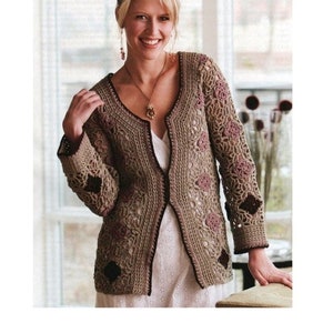 Op de afbeelding: Een gehaakt vest met een delicaat bloemenpatroon in tinten bruin en roze. Het vest heeft een V-hals en lange mouwen met een gehaakte rand.