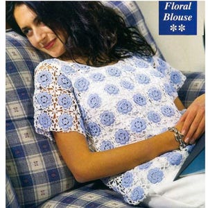 May include: White and blue floral crochet blouse. The short-sleeved top features a repeating pattern of blue flowers on a white background. The text "Floral Blouse" is in a blue box in the upper right corner.