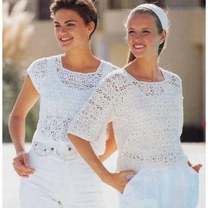 Op de afbeelding: Twee vrouwen dragen witte gehaakte tops met korte mouwen. De tops hebben een vierkant patroon en zijn kort.