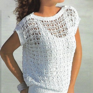 May include: White crochet top with a loose fit and short sleeves. The top has a delicate openwork pattern and a ribbed hem.