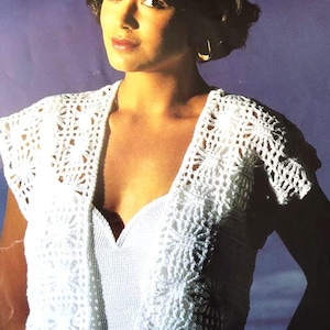 以下が含まれることがあります： Vネックと繊細な透かし模様が施された、白いクロシェのノースリーブトップ