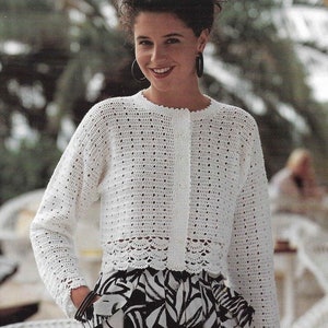 May include: White crocheted cardigan with a button closure and a scalloped hem. The cardigan is made with a delicate open stitch pattern.