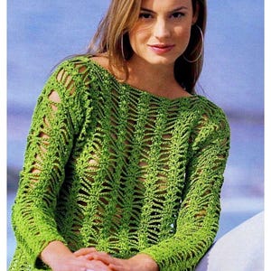 May include: A green crochet top with a loose fit and long sleeves. The top features a delicate openwork pattern.