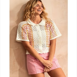 May include: A white crochet top with a colourful striped pattern. The top has a collared neckline and short sleeves.