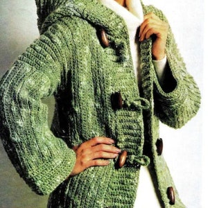 May include: A green crocheted cardigan with a hood and toggle closures. The cardigan has a speckled pattern and is made with a soft yarn.