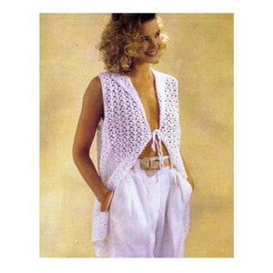 May include: A white crochet vest with a tie front and a hood. The vest is sleeveless and has a delicate openwork pattern.