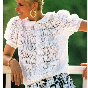 May include: A white crocheted top with a Peter Pan collar and short sleeves. The top is made with a lacy stitch and has a button closure at the front.