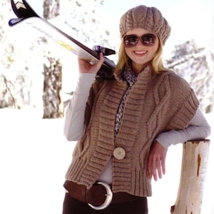 May include: A brown knitted vest with a cable knit pattern and a single button closure. The vest has a wide collar and is worn over a white long-sleeved shirt. The person is wearing a brown knit hat, sunglasses, and a brown belt with a silver buckle. The person is holding a ski on their shoulder.