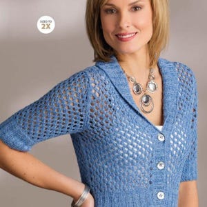 May include: A light blue, short-sleeved cardigan with a button-up front. The knitwear features a textured, open-weave design on the upper portion and a ribbed knit at the bottom. The tag reads "SIZED TO 2X".