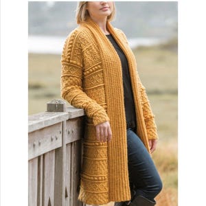 Peut inclure: Un long cardigan en crochet jaune avec un motif texturé et un col châle.