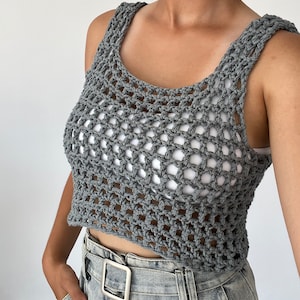 May include: Grey crochet tank top with a loose, open weave. The top is cropped and has a scoop neck.
