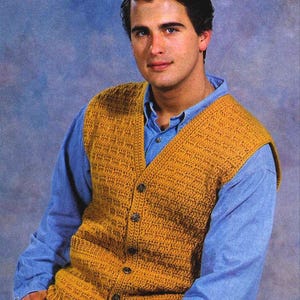 May include: A crocheted waistcoat with a V-neck and button fastening. The waistcoat is a solid mustard yellow colour.