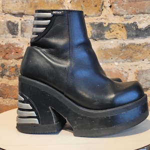 May include: Black leather platform boot with silver accents. The boot features a chunky platform sole and a side zipper. The word "DESTROY" is visible on the top of the boot.