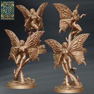 May include: Four golden fairy figurines with wings, each standing on a base with a leafy stem and mushrooms. The fairies are wearing detailed clothing and have long flowing hair.