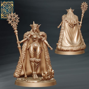 Könnte beinhalten: Goldfarbene Figur einer weiblichen Fantasy-Figur, die einen Stab mit Schneeflockenmuster hält. Sie trägt eine Rüstung, einen Umhang mit Fellbesatz und eine Krone. Die Figur steht auf einem Sockel mit Kristallformationen.
