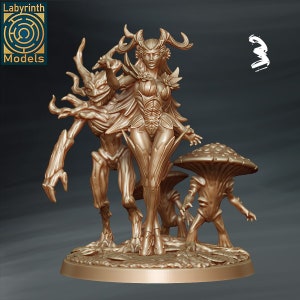 May include: A golden painted miniature figurine set featuring a female figure with antlers and leafy armor, a tree-like creature, and a mushroom creature. The figures are standing on a circular base.