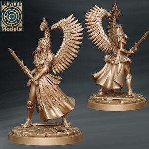 May include: A gold-coloured miniature figurine of a female angel warrior with wings, holding a sword. The figure is standing on a circular base with a stone-like texture.