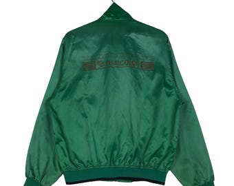 May include: A green satin bomber jacket with a black zipper and black ribbed cuffs and waistband. The back of the jacket has the text "YOU'LL GET SUPERIOR QUALITY AND PERFORMANCE FROM OUR TECHNOLOGY. WE'RE ALWAYS TRYING TO MAKE IT BETTER." and the logo "FUJICOLOR" in brown.