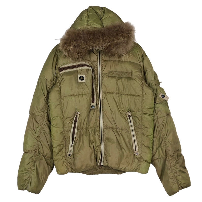 Puede incluir: Una chaqueta acolchada verde con capucha forrada de piel. La chaqueta tiene cierre de cremallera y varios bolsillos.