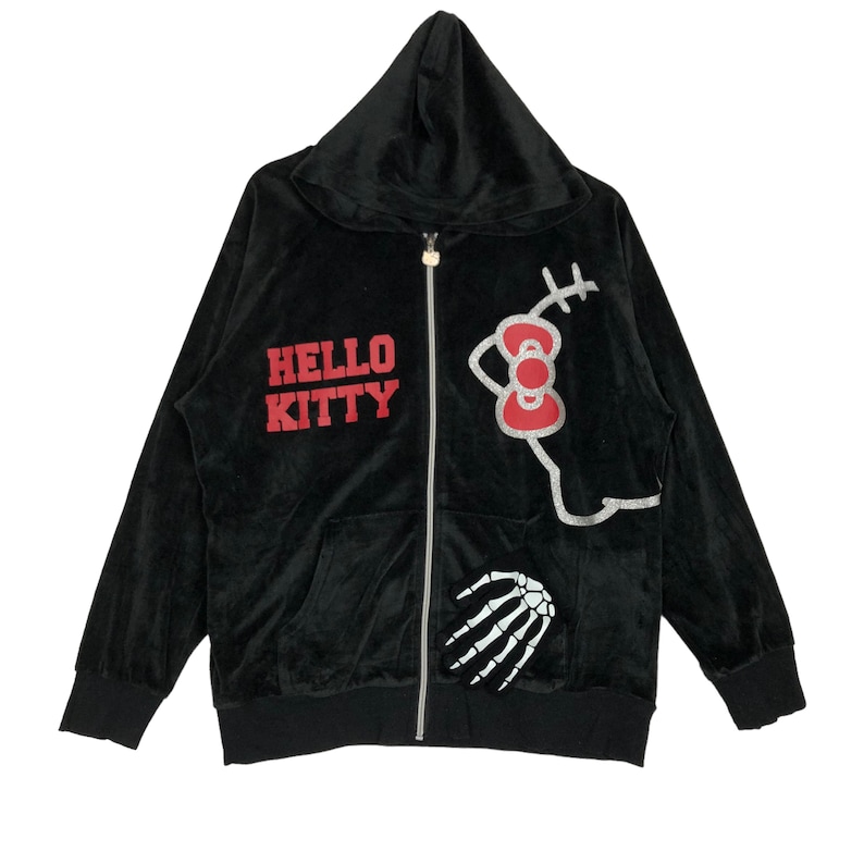 May include: Black velour zip-up hoodie with a Hello Kitty graphic and a skeleton hand design. The hoodie has a red and white Hello Kitty bow and the text "Hello Kitty" in red.