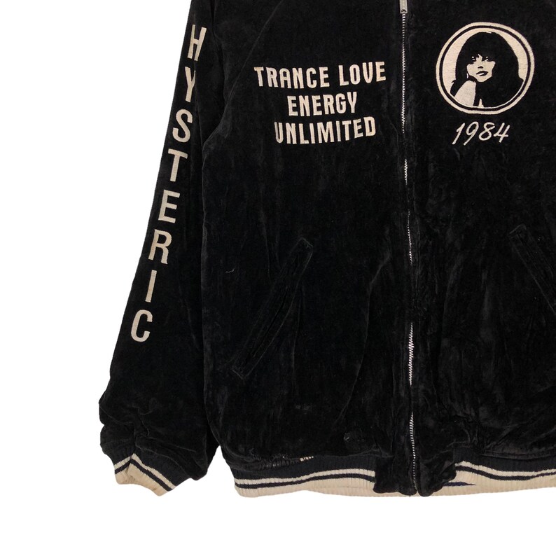 May include: Black velvet bomber jacket with white lettering that reads "HYSTERIC" on the left sleeve and "TRANCE LOVE ENERGY UNLIMITED 1984" on the front.