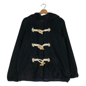 May include: A black hooded duffel coat with toggle closures and a front pocket. The coat features a fuzzy interior lining and wooden toggles. The coat is hanging on a wooden hanger.