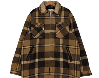 May include: A brown and tan plaid flannel jacket with a zipper closure and two large flap pockets on the front.