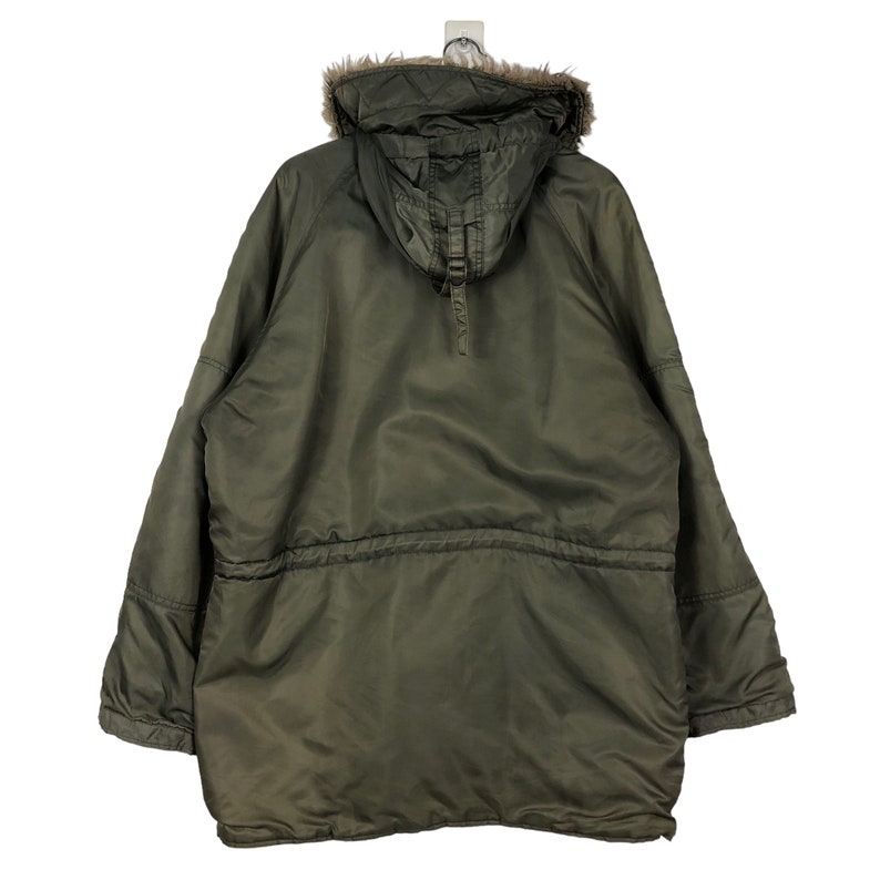 Op de afbeelding: Olijfgroene parka-jas met een met imitatiebont gevoerde capuchon. De jas heeft een taille met trekkoord, een ritssluiting over de hele lengte en meerdere zakken. De parka is ontworpen voor koud weer en heeft een relaxte pasvorm.